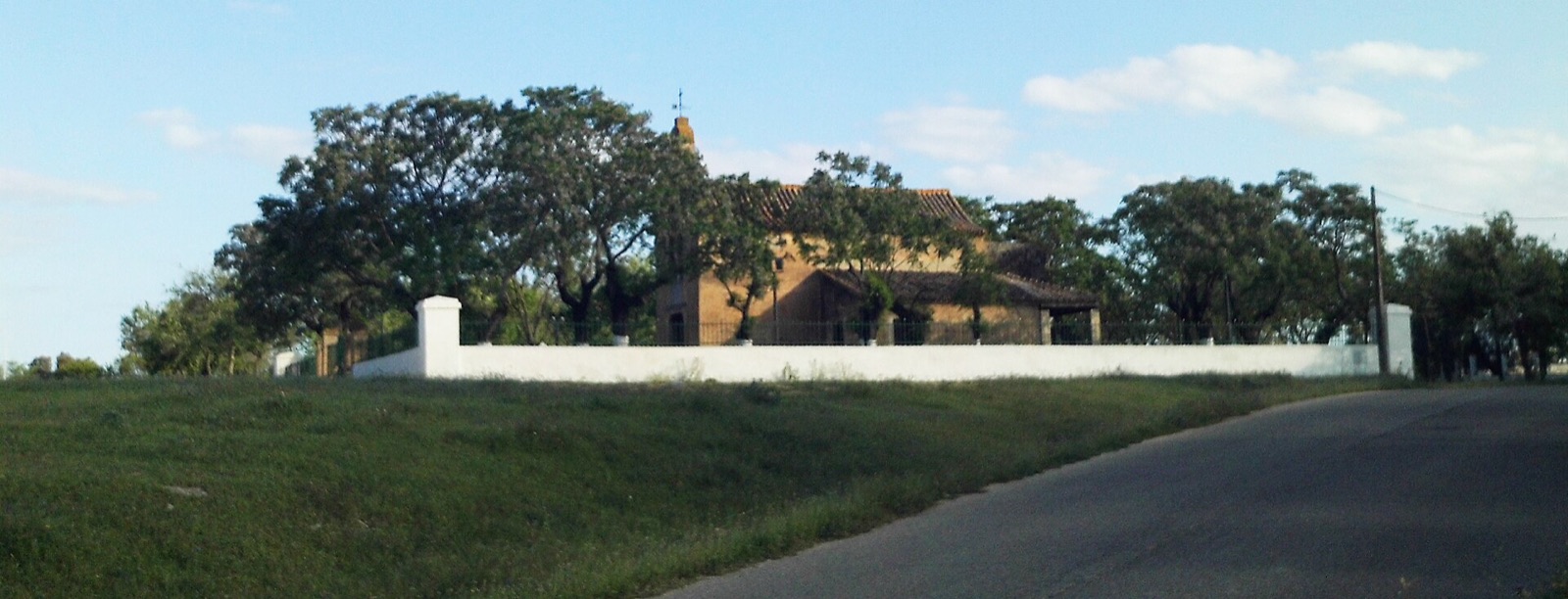 La ermita de Valme, blanca, con su espadaña, en el cortijo de Cuarto