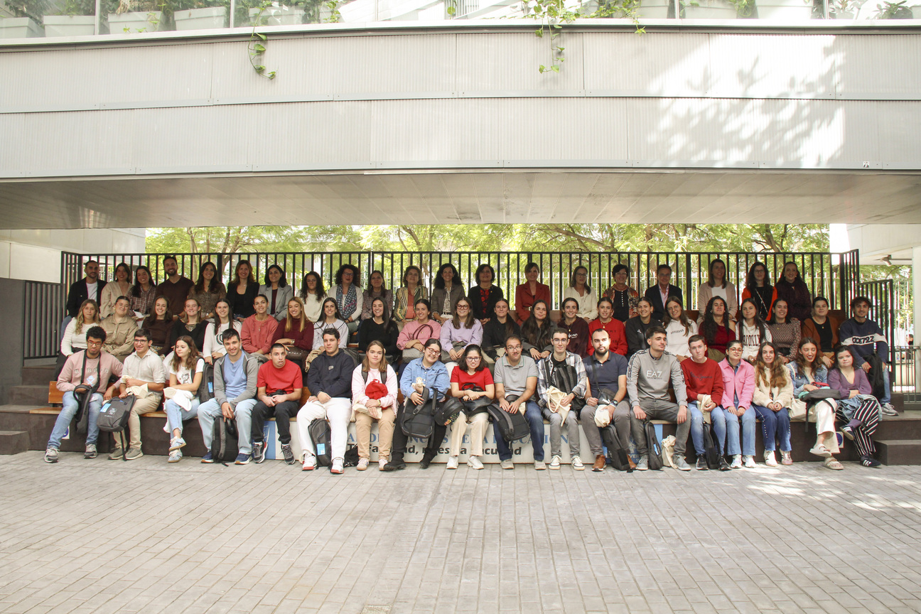 Un grupo numeroso de jóvenes posa sentado y de pie en gradas bajo una estructura metálica, al aire libre.