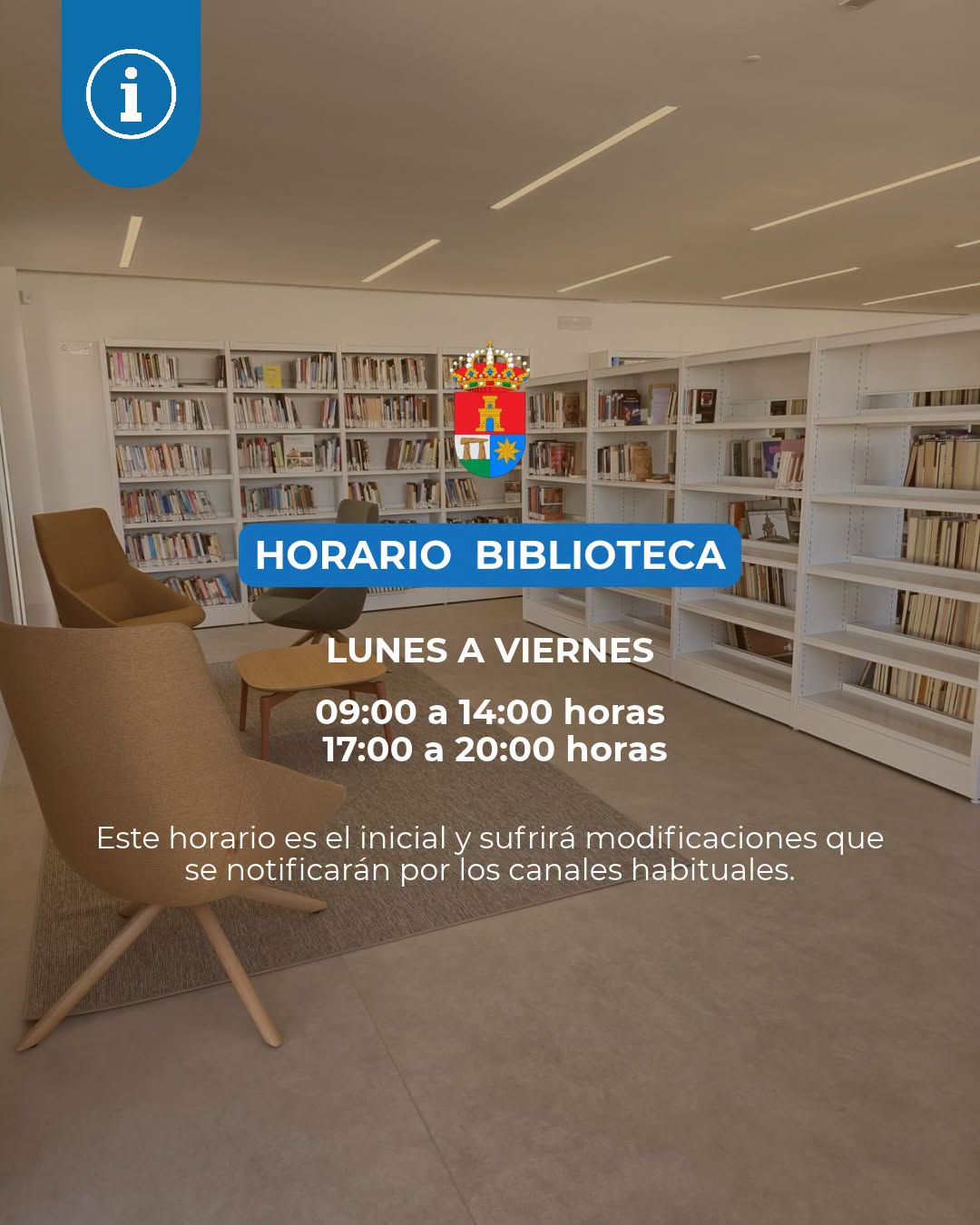 Sala de biblioteca con estanterías llenas de libros, butacas y mesas bajas, y un cartel azul con el horario.